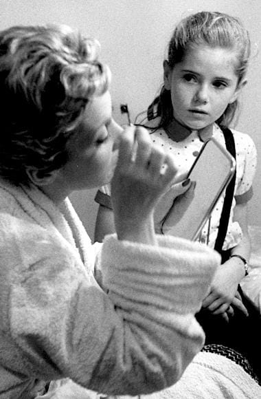 1957 Woman applying mascara using a small brush